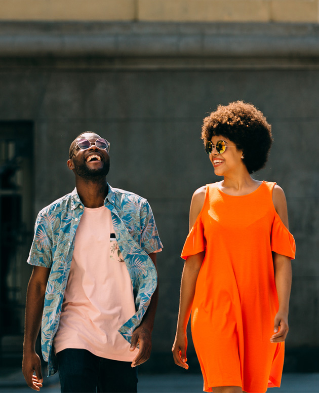 Two friends walking outside in the sunshine.